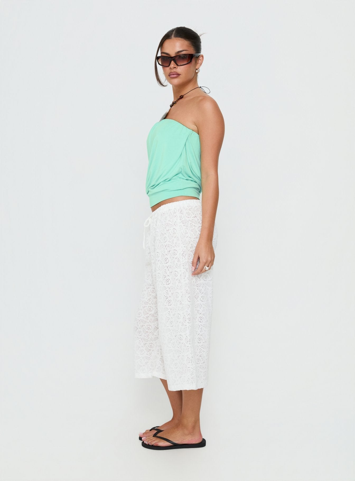 Discover the Kiss Me Quick 3/4 Lace Drawstring Pants in White featuring mid-rise womens-regular-pants side view of model wearing Princess Polly