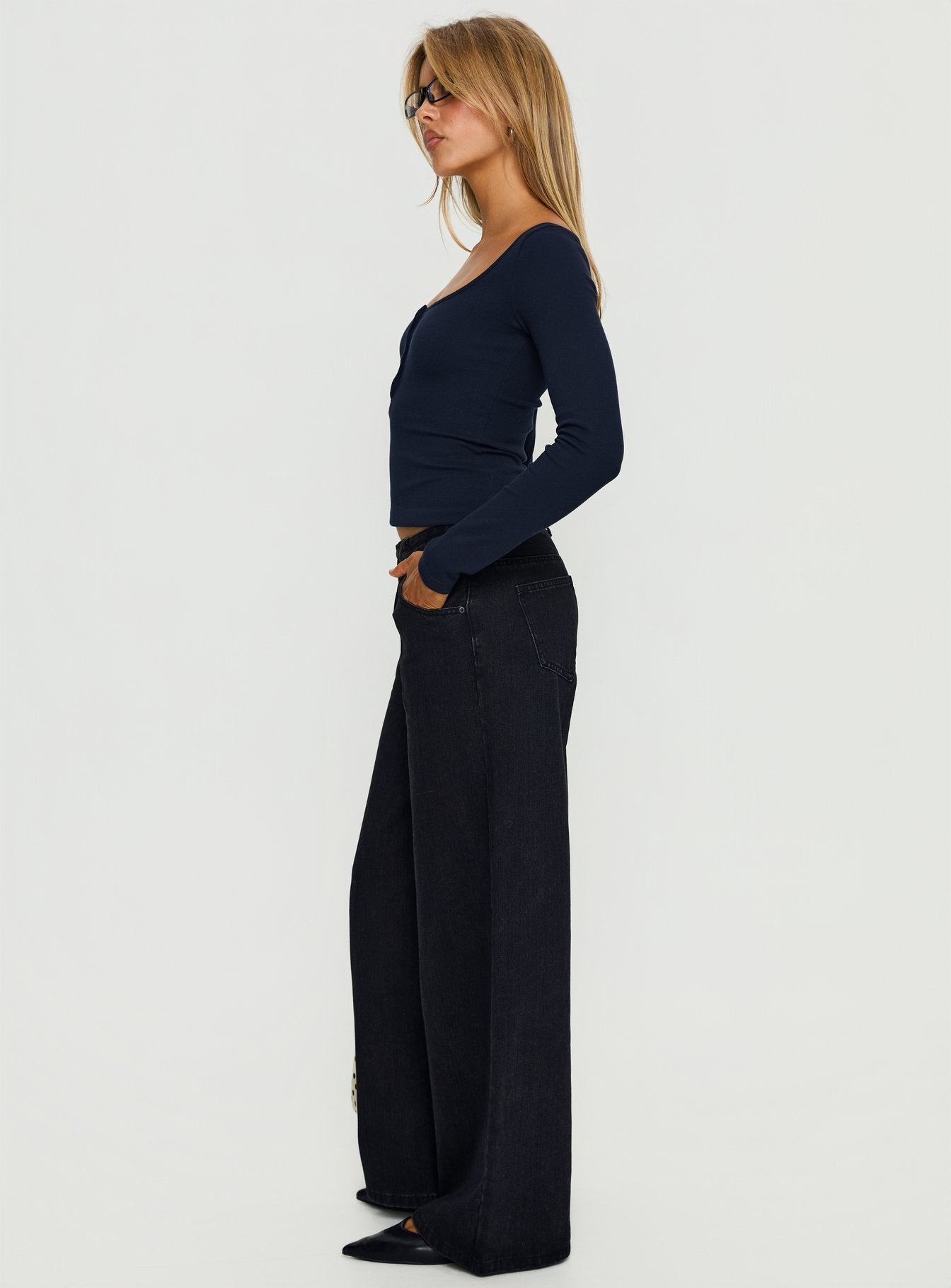 side view of model wearing Princess Polly Supercut Low Rise Baggy Pleat Jeans Washed Black Low Rise Jeans 