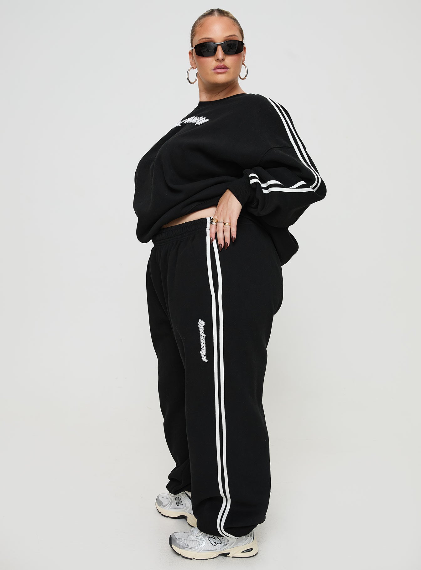 side view of model wearing Princess Polly Princess Polly Track Pants Stripe Black / White Curve High Waisted Pants 