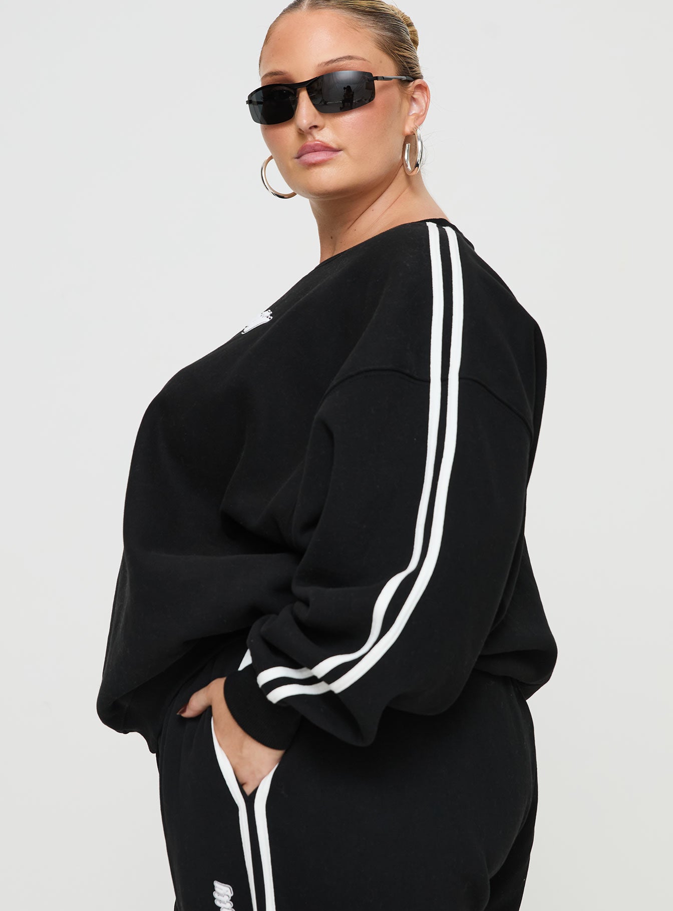 side view of model wearing Princess Polly Princess Polly Crew Neck Sweatshirt Stripe Black / White Curve 