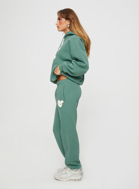side view of model wearing Princess Polly Princess Polly Track Pants Bubble Text Sage / Eggshell Mid Rise 