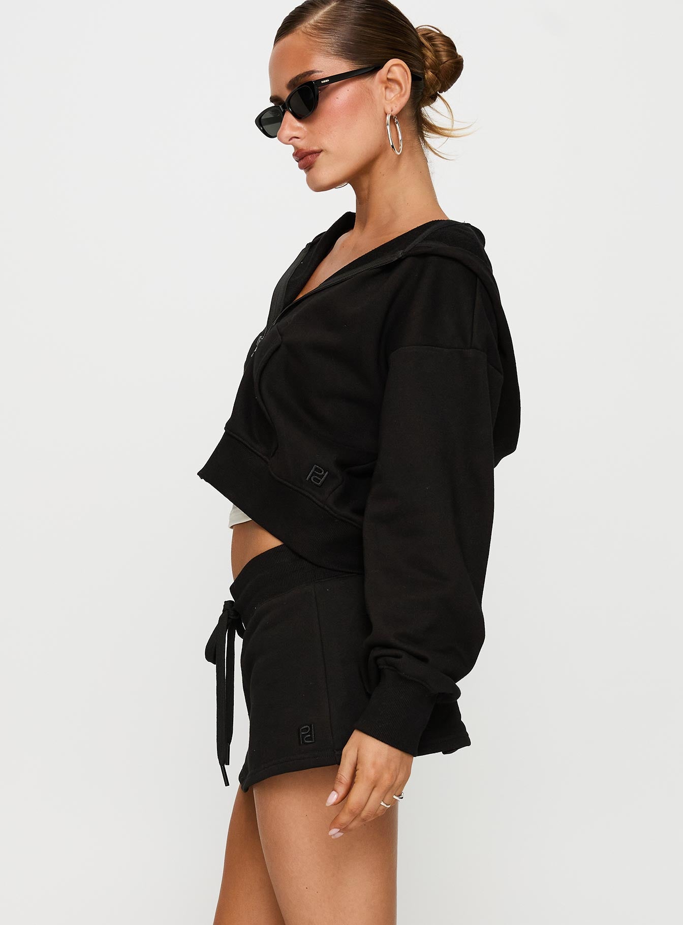 side view of model wearing Princess Polly Down Low Fleece Skort Black Low Rise Shorts 