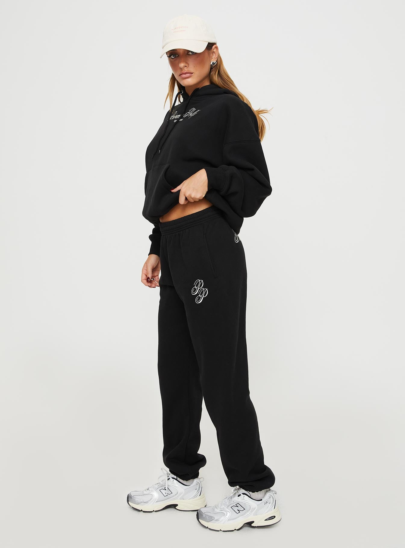 side view of model wearing Princess Polly Princess Polly Track Pants Script Black / Ivory High Waisted Pants 