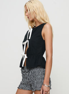 side view of model wearing Princess Polly Ryoti Top Black Sleeveless Crew Neck 