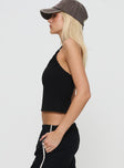 side view of model wearing Princess Polly Glint Asymmetrical Top Black Sleeveless Asymmetric Neckline 