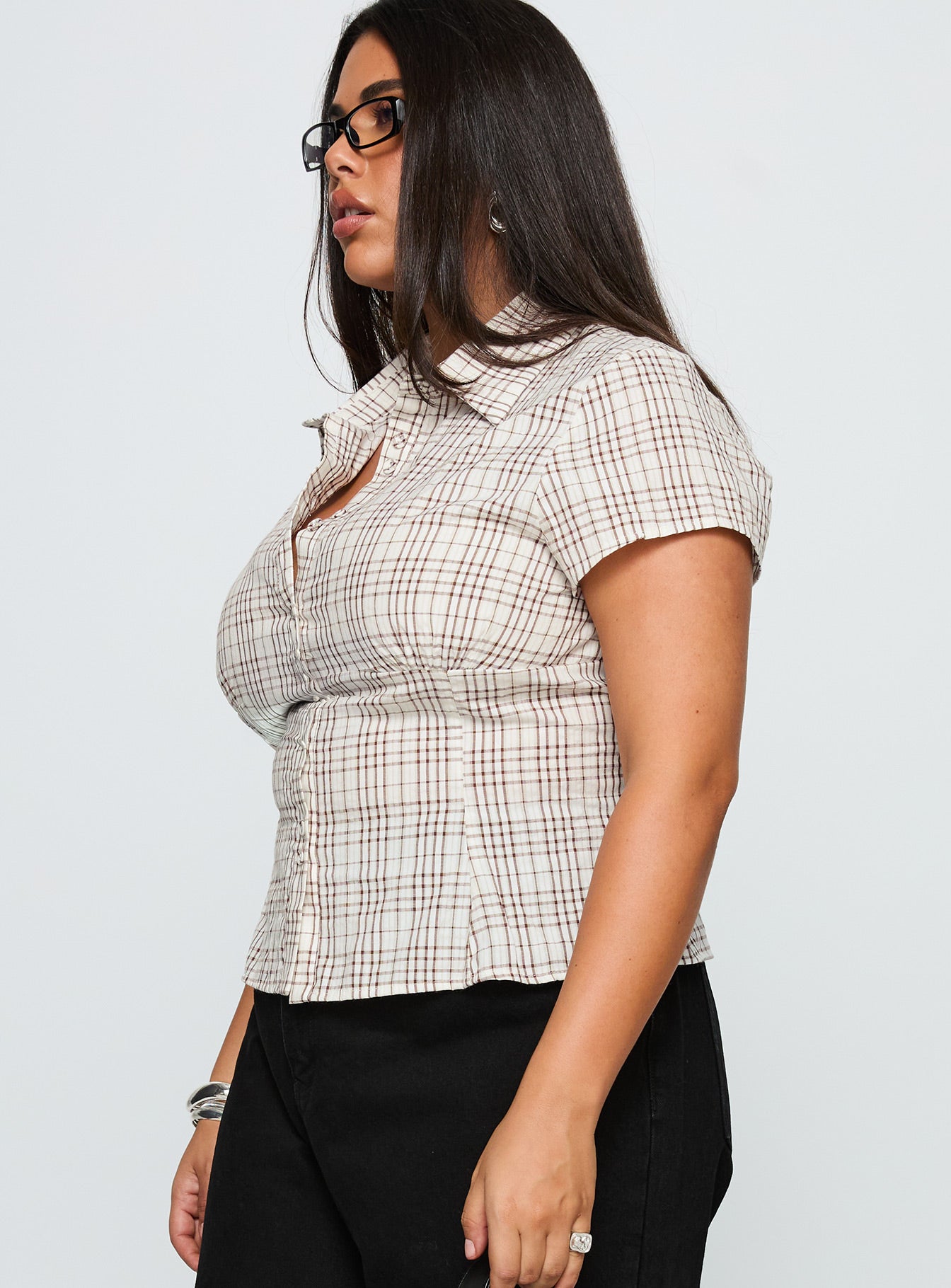 side view of model wearing Princess Polly Cottesloe Blouse Top Brown Check Curve Short Sleeves V-Neck 