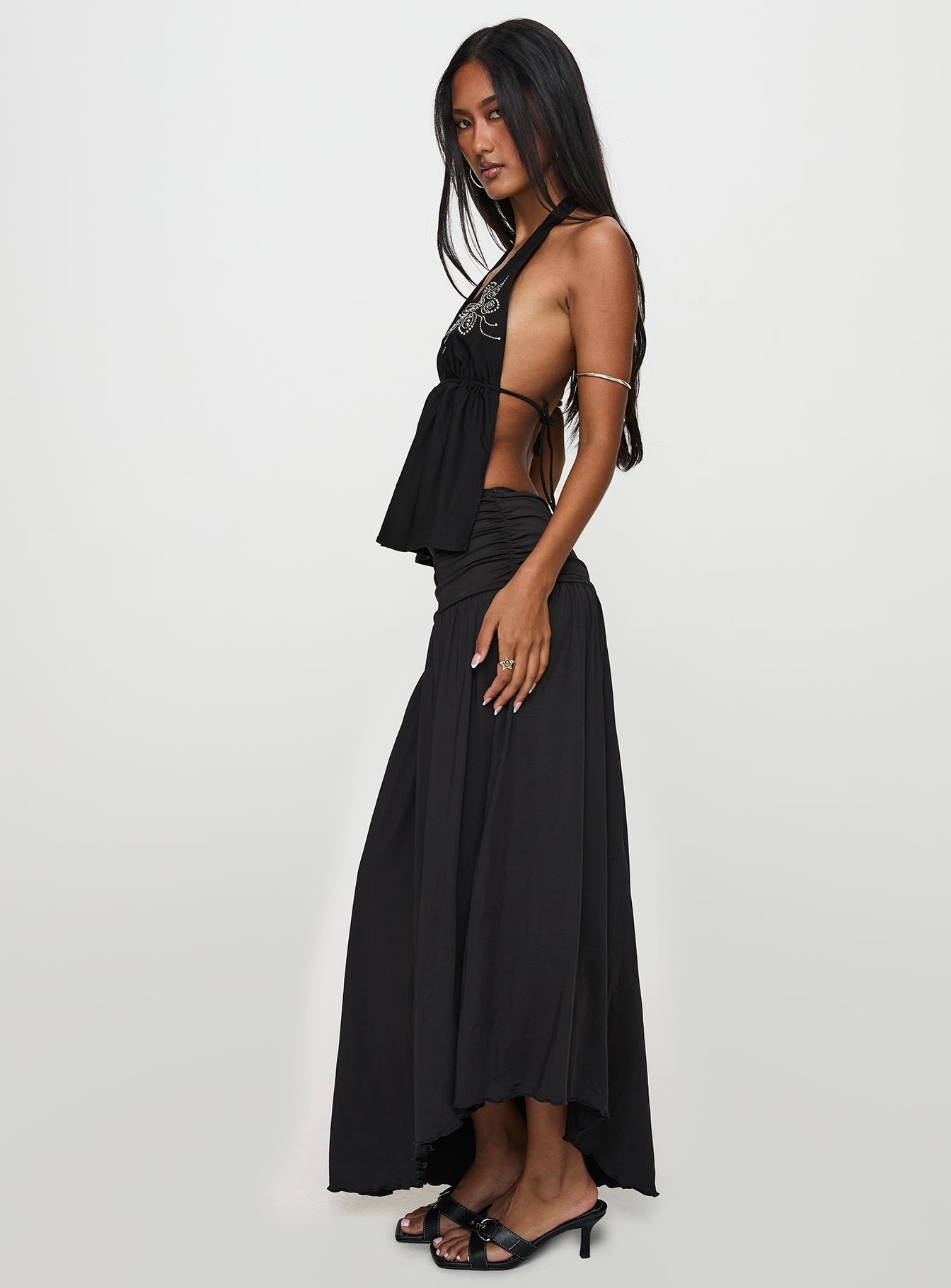   side view of model wearing Princess Polly Gezabele Asymmetrical Maxi Skirt Black Maxi 