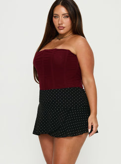   side view of model wearing Princess Polly Sonsie Mini Skirt Black / White Polka Curve 