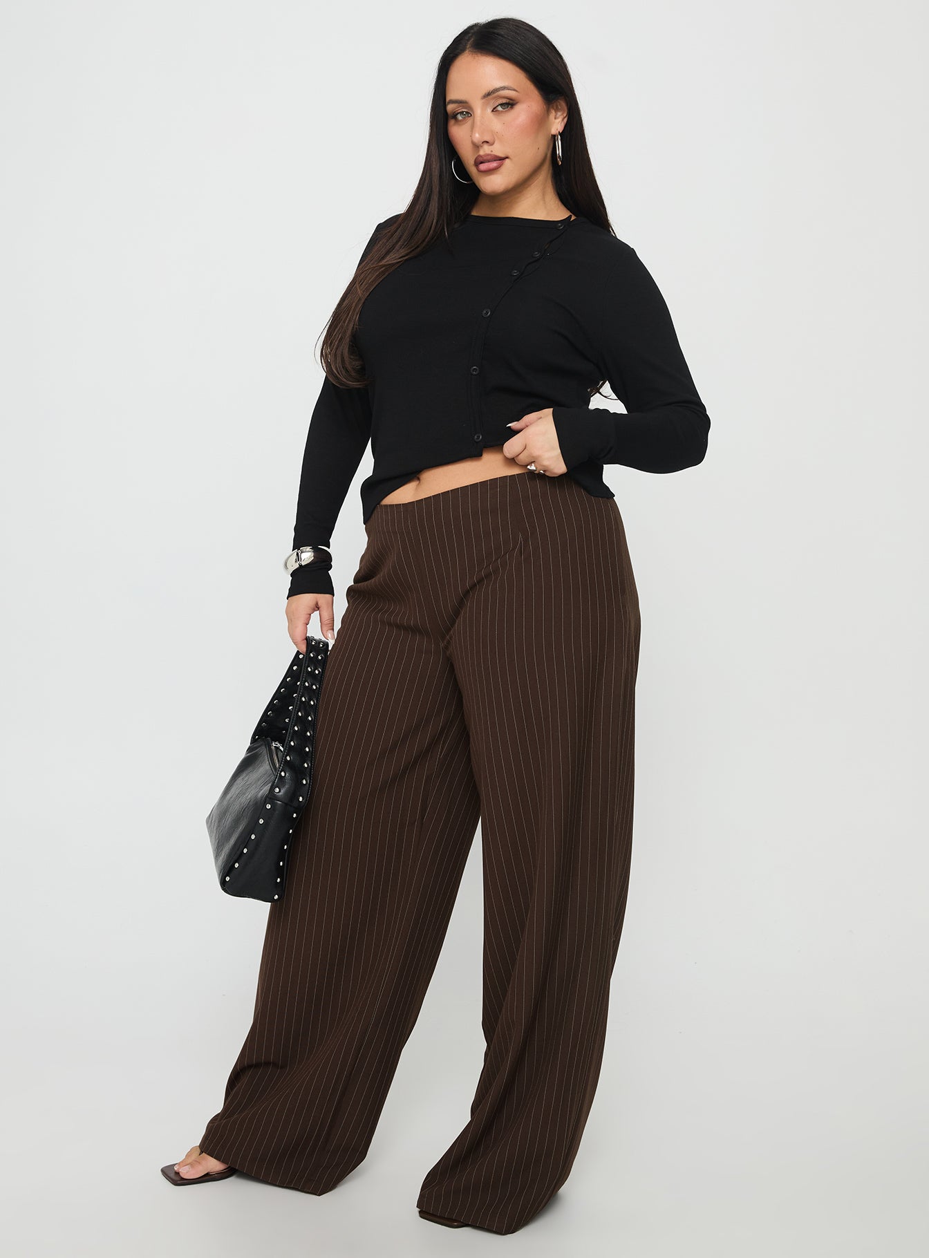 side view of model wearing Princess Polly Khane Low Rise Wide Leg Pant Brown Pinstripe Curve Low Rise Pants 