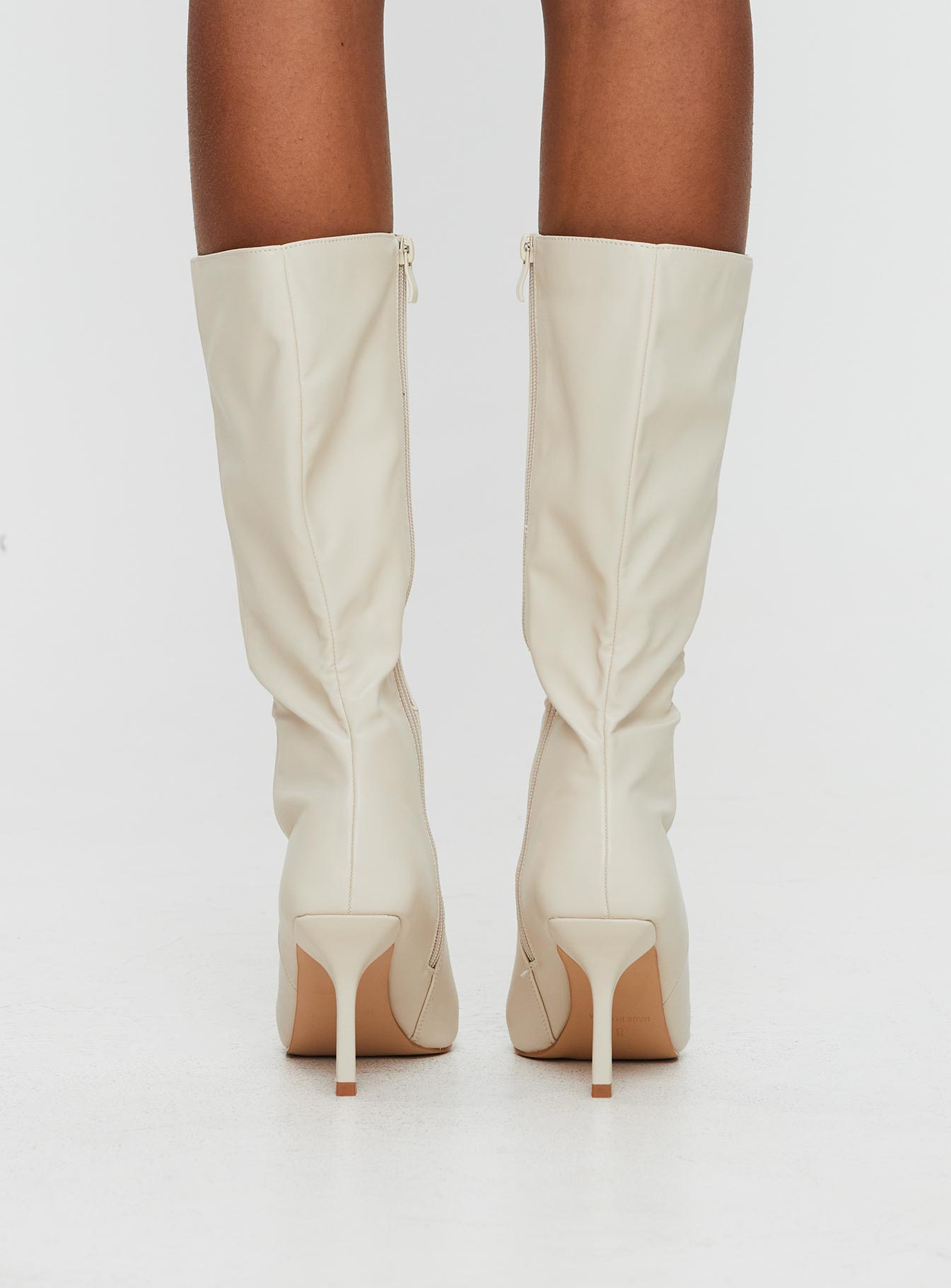 Cream Knee-high boots Faux leather material, zip fastening at inside, pointed toe, stiletto heel