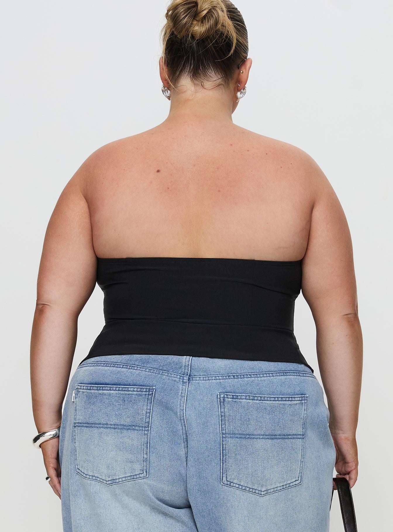 back view of model wearing Princess Polly Flounce Strapless Top Black Curve Sleeveless straight 