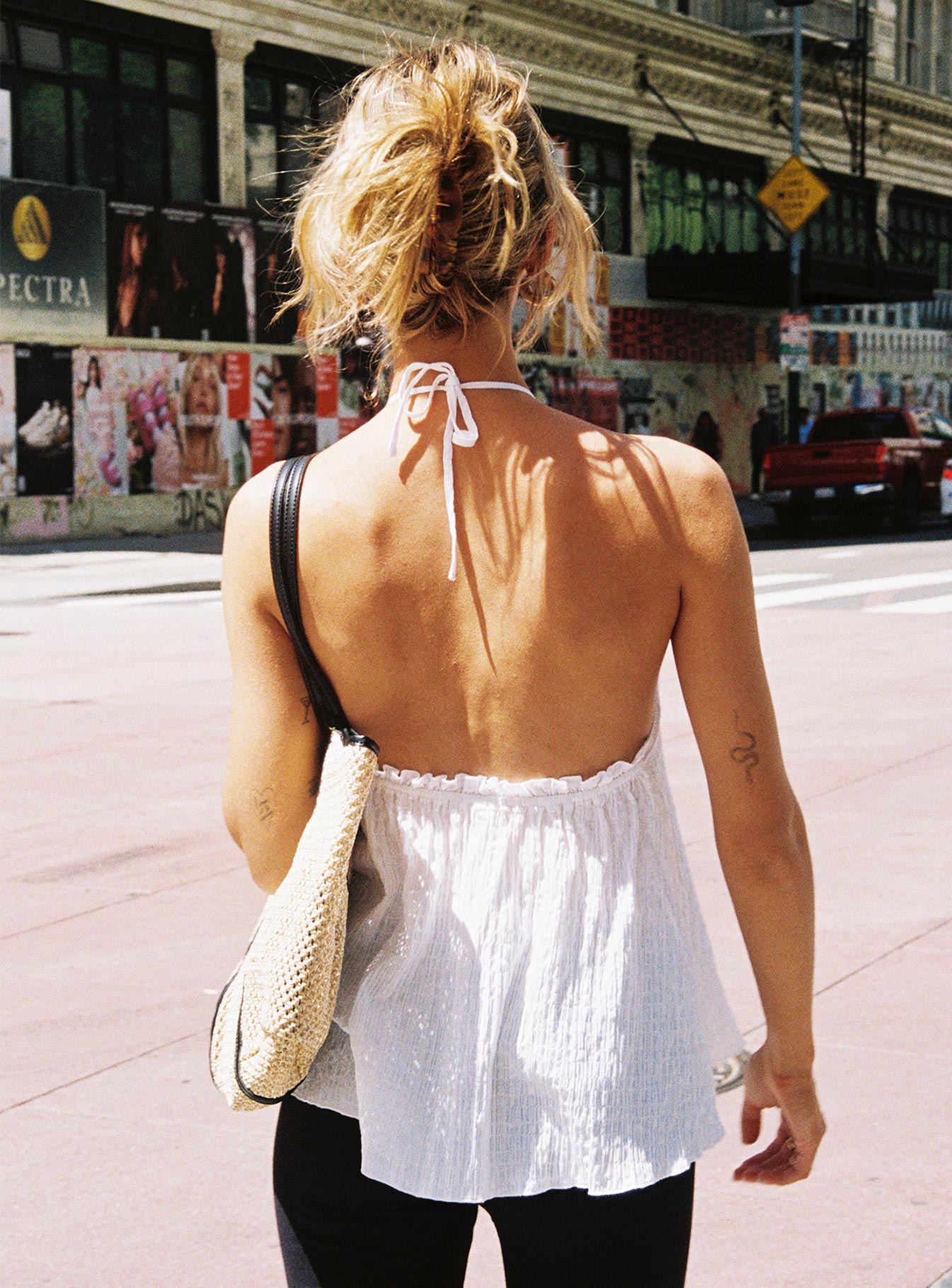 back view of model wearing Princess Polly Flutter Halter Top White Sleeveless High Neck 