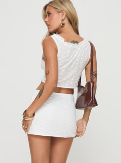 Broderie anglaise set Crop top, v-neckline, fixed shoulder straps, hook & eye fastening down front Mid rise mini skirt, invisible zip fastening down side Non-stretch material, partially lined