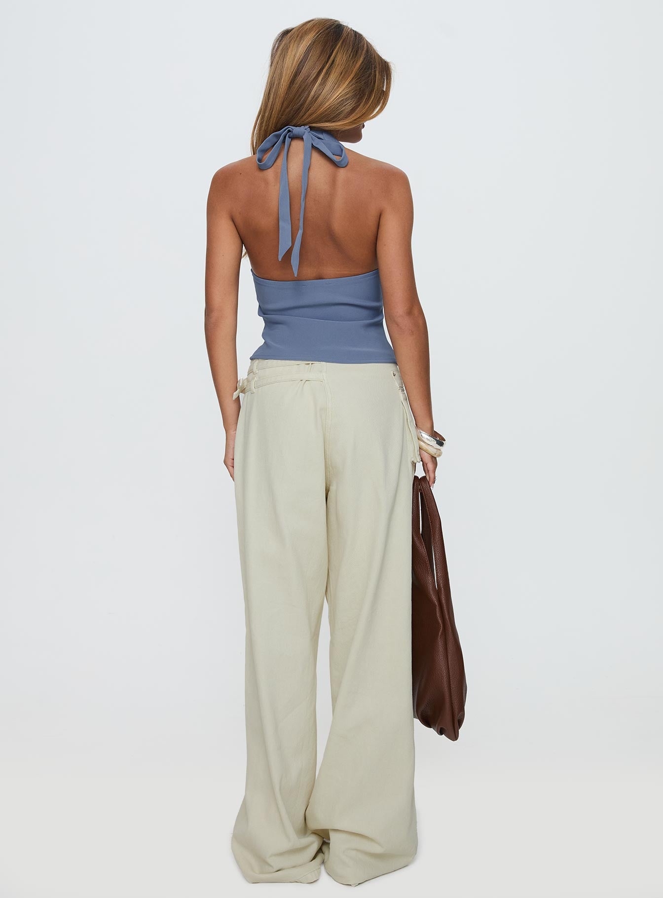 back view of model wearing Princess Polly Paltrow Mid Rise Wide Leg Cargo Jeans Cream Petite Low Rise Jeans 