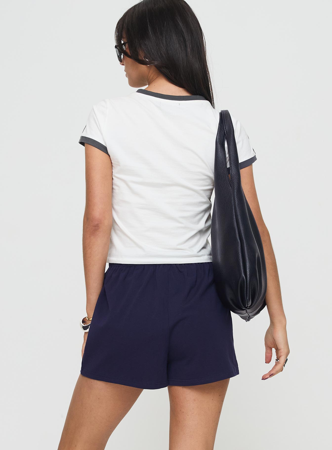 back view of model wearing Princess Polly Gavine Shorts Navy mid-rise 