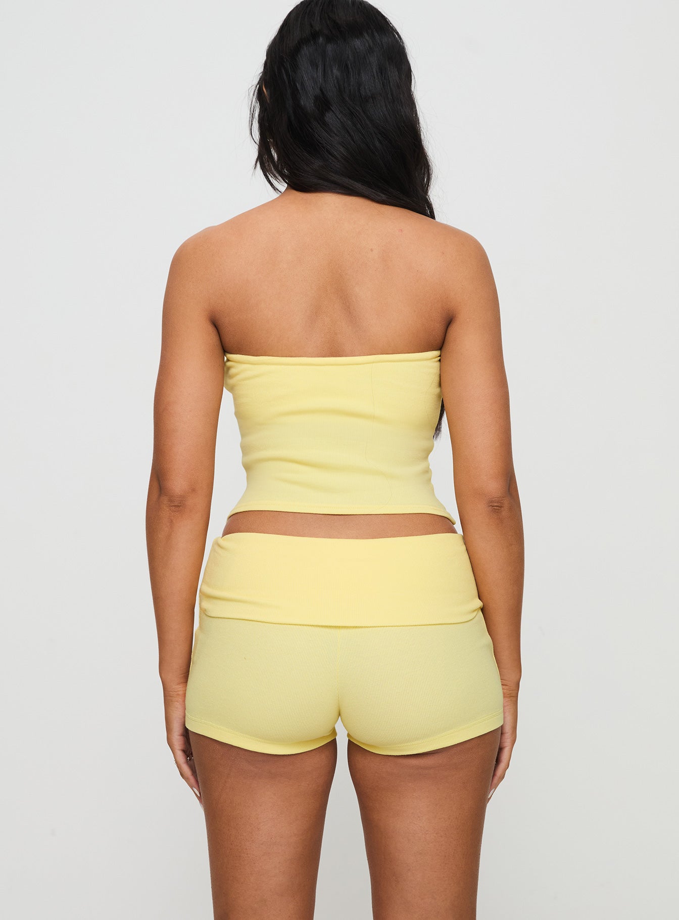 back view of model wearing Princess Polly Baseline Low Rise Rib Shorts Yellow Low Rise Shorts 