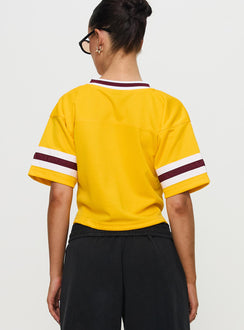 back view of model wearing Princess Polly ASU Football Jersey Gold Half Sleeves V-Neck 