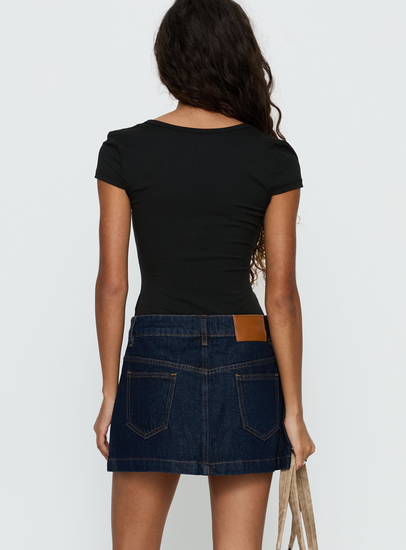 back view of model wearing Princess Polly Nicolina Low Rise Denim Mini Skirt Raw Denim Mini Skirts 