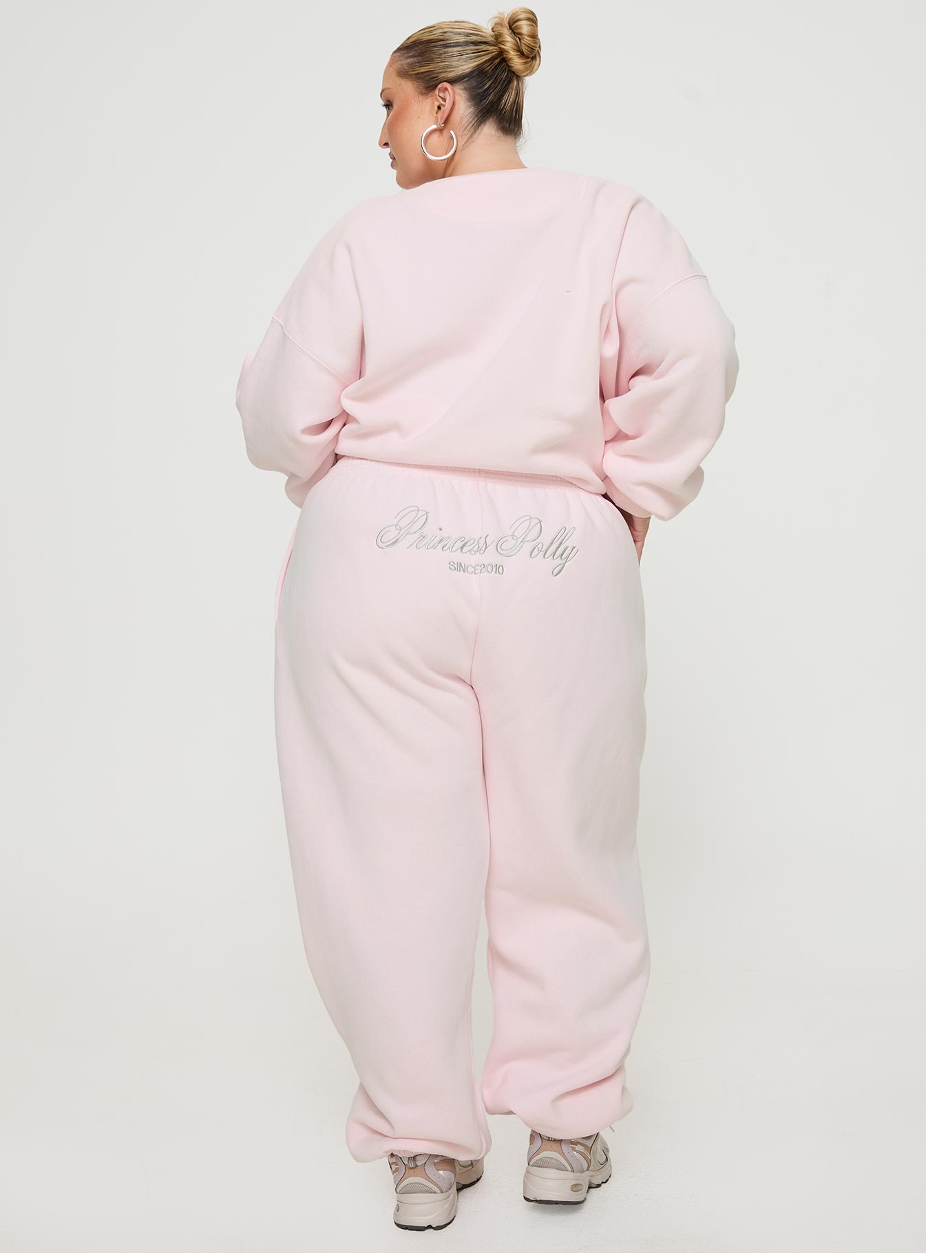 back view of model wearing Princess Polly Princess Polly Track Pants Script Baby Pink / Grey Curve 