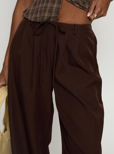 side view of model wearing Princess Polly Idolised Pleated Tie Waist Pant Chocolate Brown Mid Rise Pants 