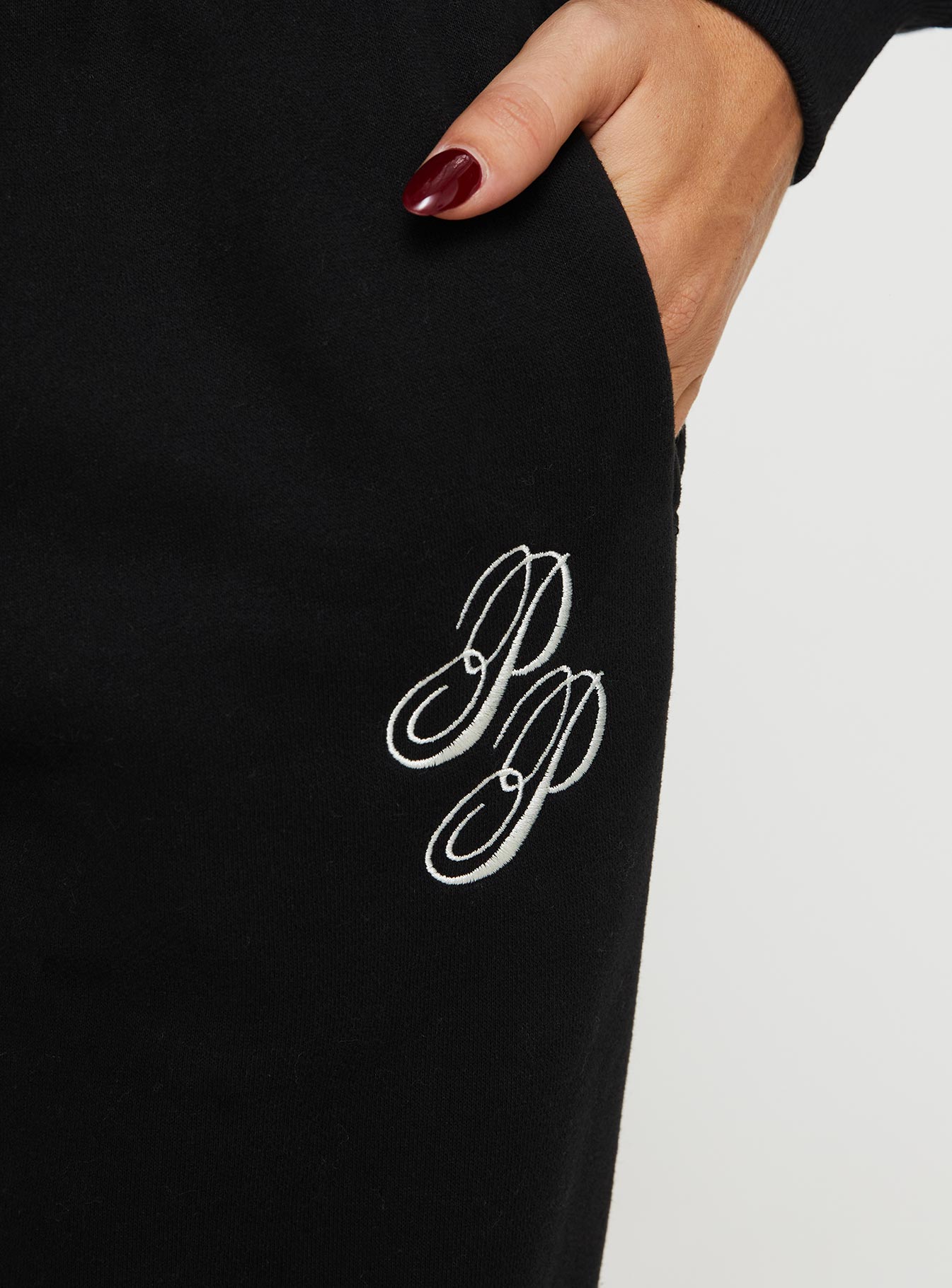 side view of model wearing Princess Polly Princess Polly Track Pants Script Black / Ivory High Waisted Pants 