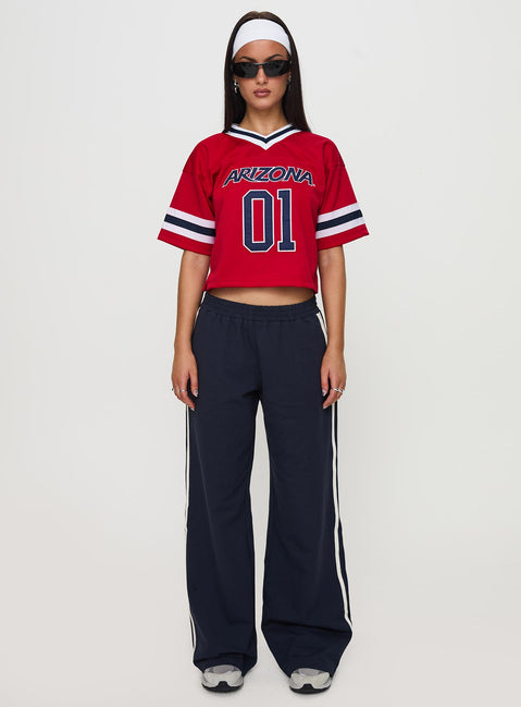 side view of model wearing Princess Polly U of A Football Jersey Red Half Sleeves V-Neck 