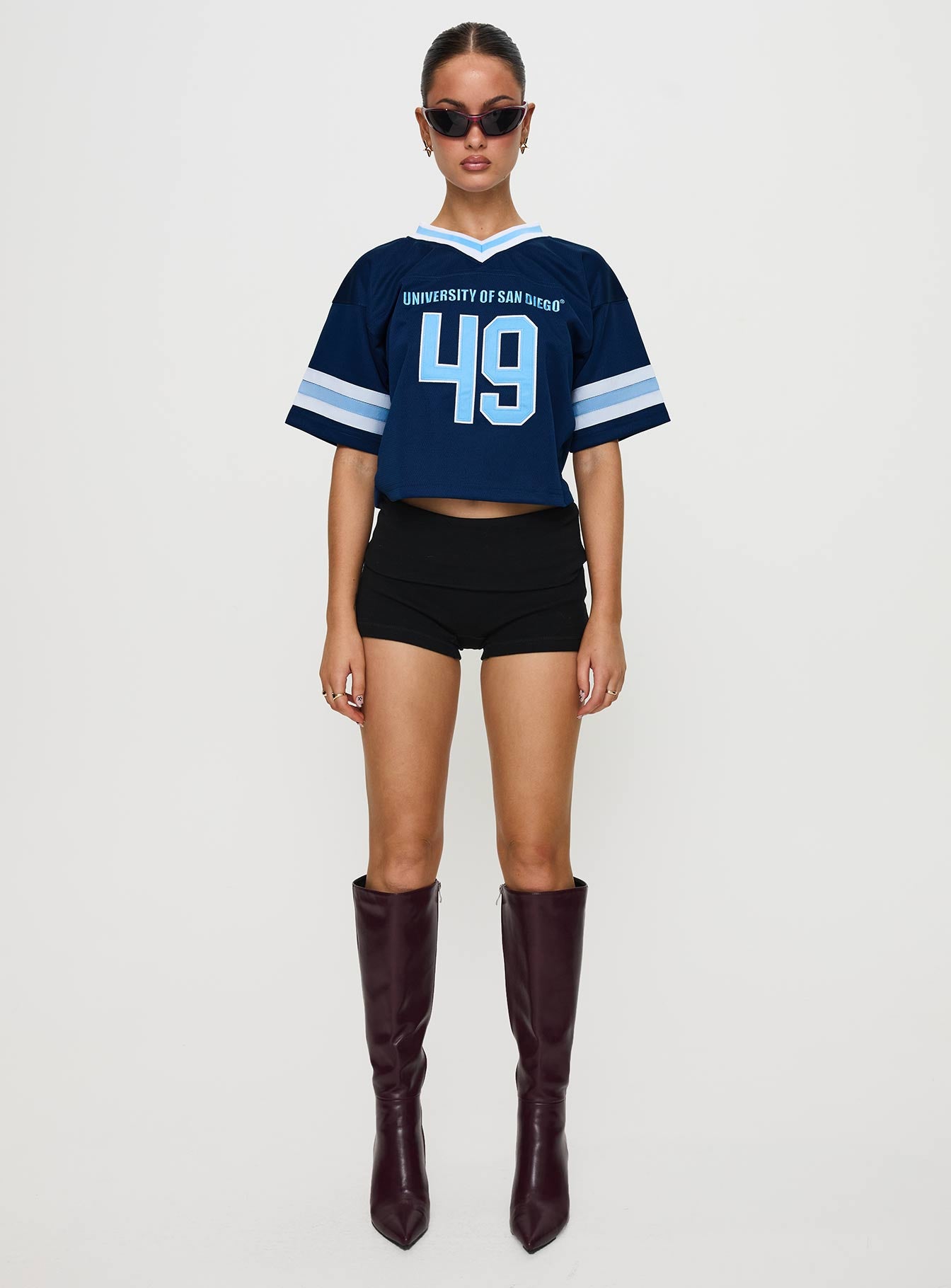 side view of model wearing Princess Polly USD Football Jersey Navy Half Sleeves V-Neck 