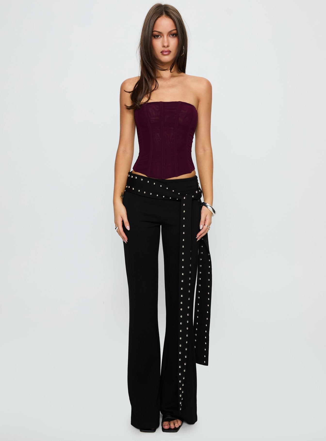 side view of model wearing Princess Polly Nikolia Studded Wrap Belt Pants Black Mid Rise Pants 