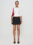   side view of model wearing Princess Polly Dapple Bias Mini Skirt Black Polka Dot Mini Skirts 