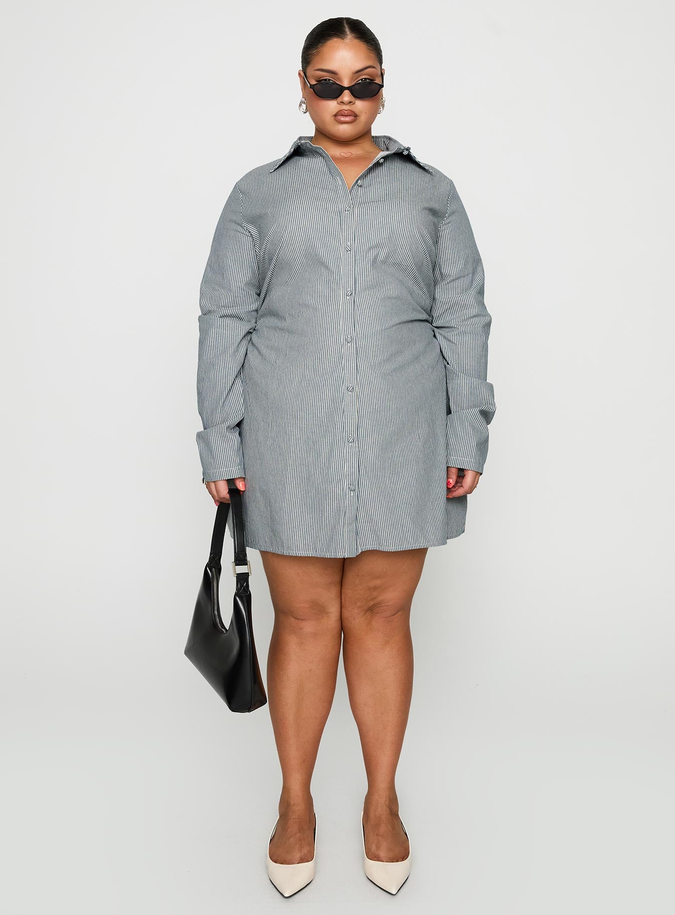 side view of model wearing Princess Polly Publicity Long Sleeve Mini Dress Blue Pinstripe Curve V-Neck 