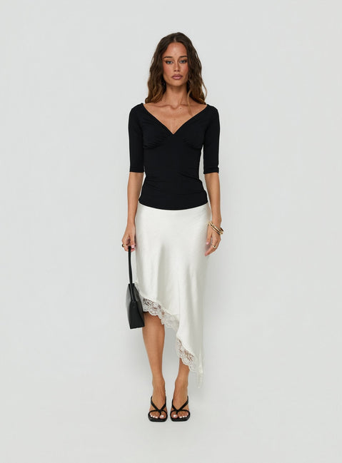 Featuring the Koletta Asymmetrical Lace Trim Satin Midi Skirt in Ivory with fitted silhouette front view of model wearing Princess Polly