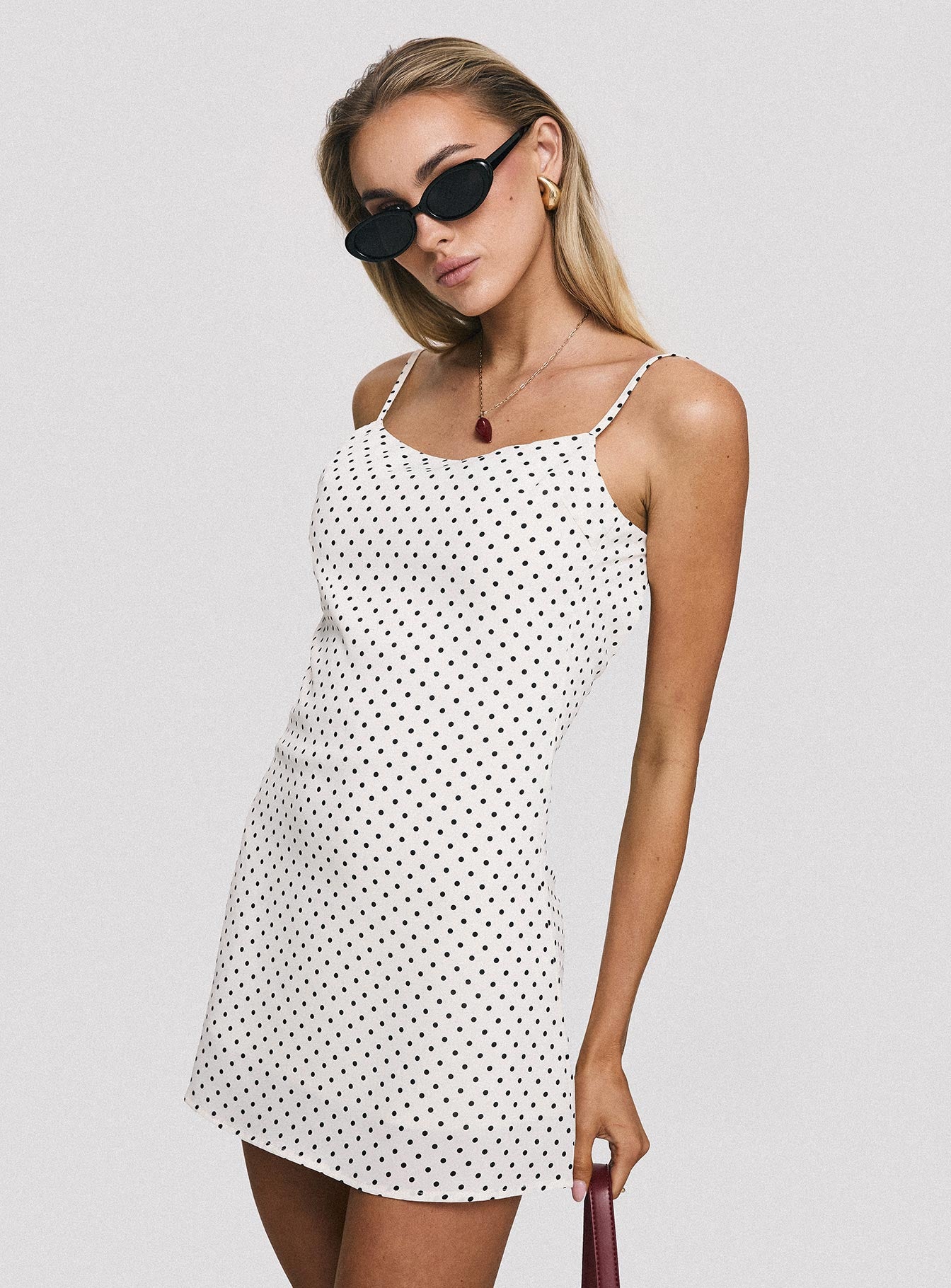 side view of model wearing Princess Polly Cookie Mini Dress White Polka Dot Scoop Neck 