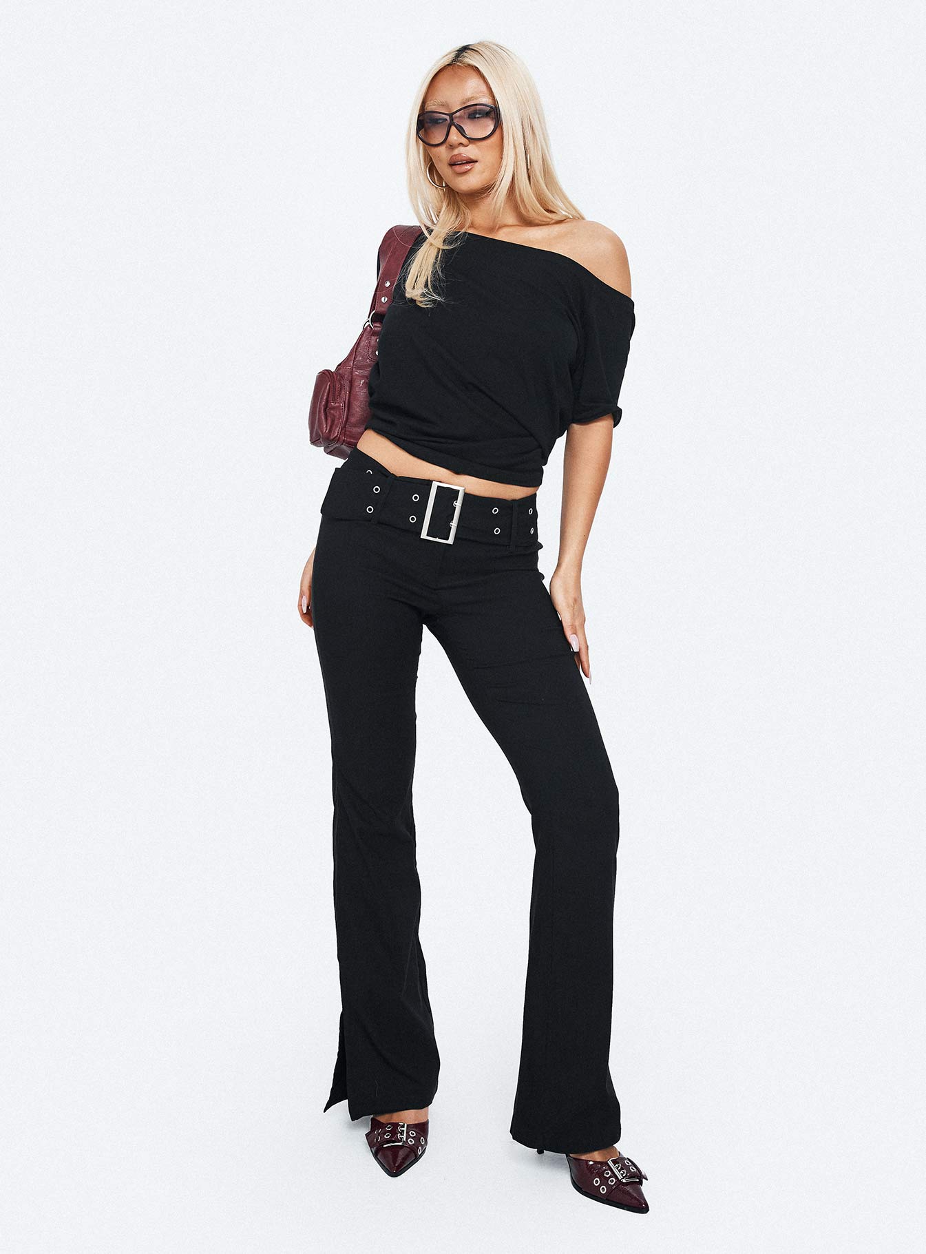 side view of model wearing Princess Polly Kortnee Eyelet Detail Flare Leg Pants Black Low Rise Pants 