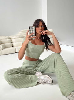 Two piece set Knit ribbed material Crop top Inner silicone strip along shoulders Wide neckline High waisted pants Thick elasticated waistband Twin hip pockets Wide flared leg