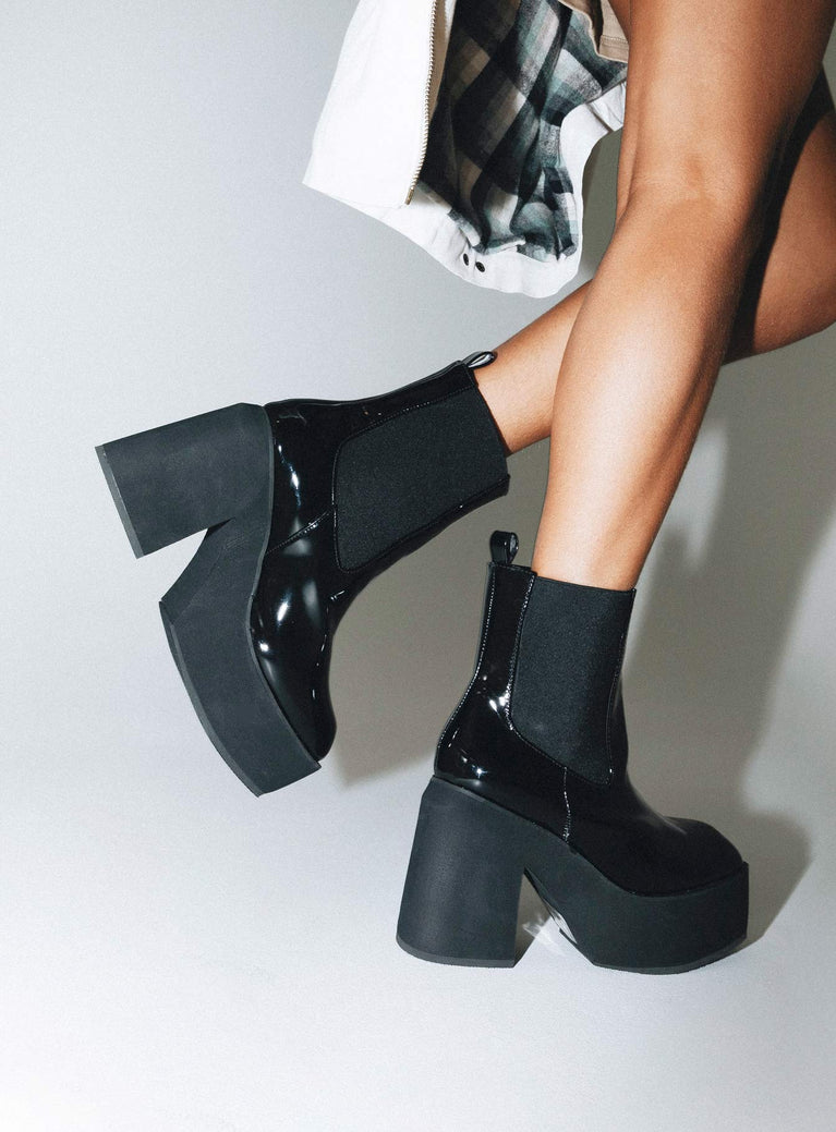 Black platform boots Faux patent leather Ankle boot style Square toe Elastic gusset detailing Pull tab at back