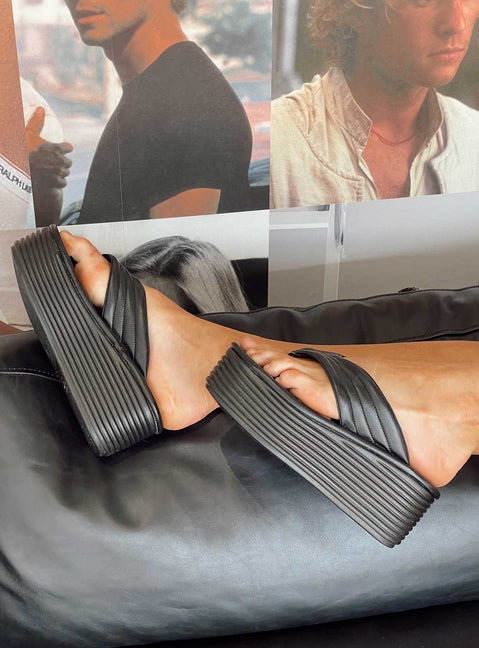 Sandals 100% polyurethane Faux leather material Flip-flop style upper  Exaggerated platform base  Rounded toe  Padded footbed 