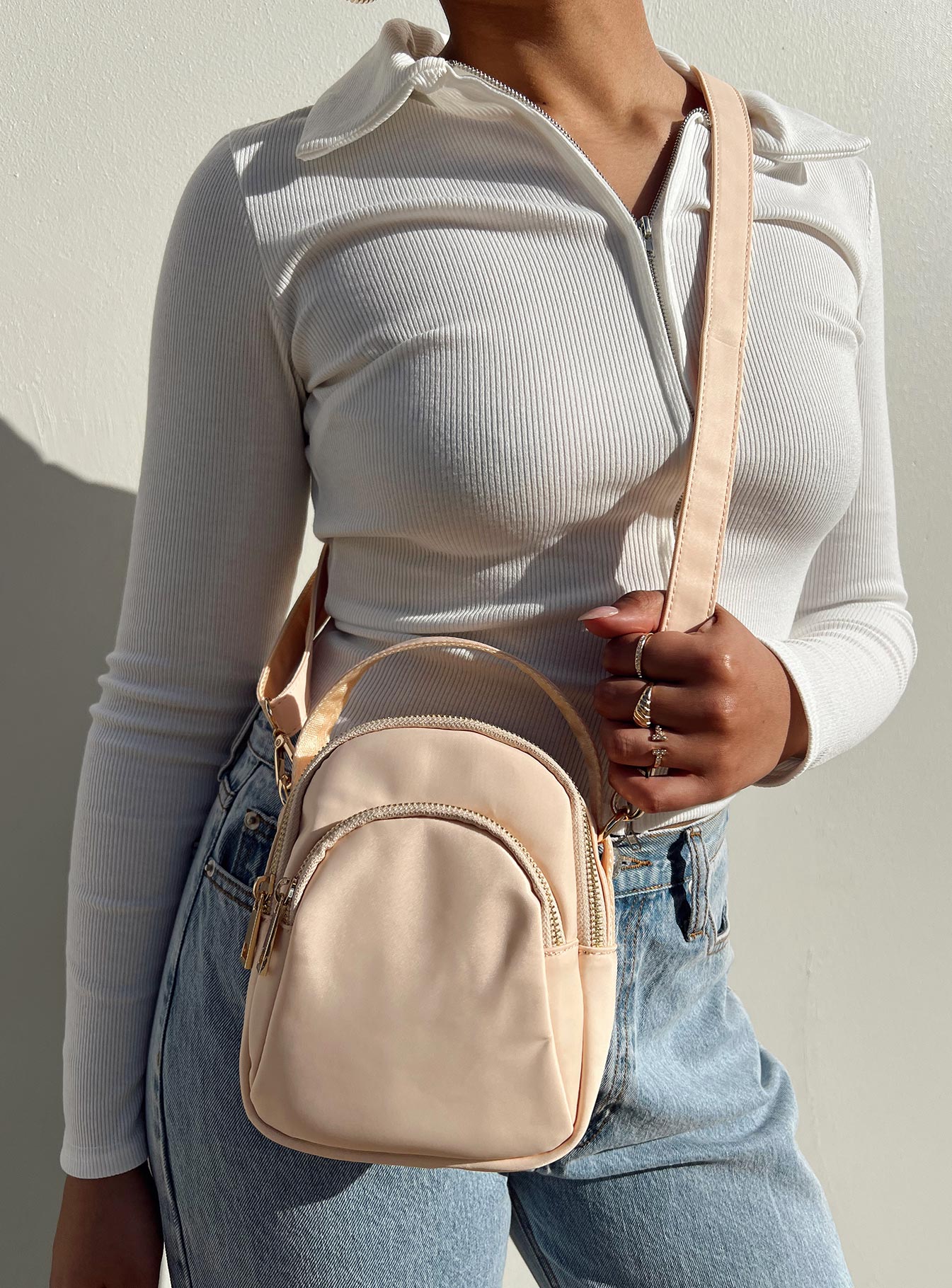 Cream crossbody bag Nylon material Fixed handle Adjustable & removable crossbody strap Three seperate compartments Zip fastenings Gold-toned hardware Flat base