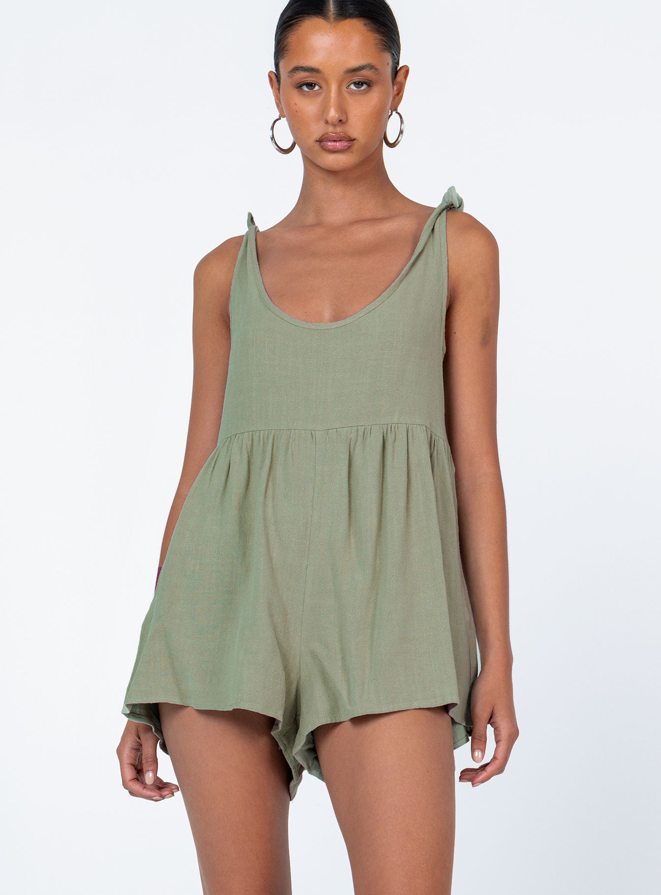 Romper loose fitting Linen look material  Tie shoulder straps  Wide neckline  Gathered waist  Twin hip pockets 