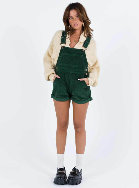 Khaki overalls Cord material  Adjustable shoulder straps  Button fastening at hips  Chest pocket 