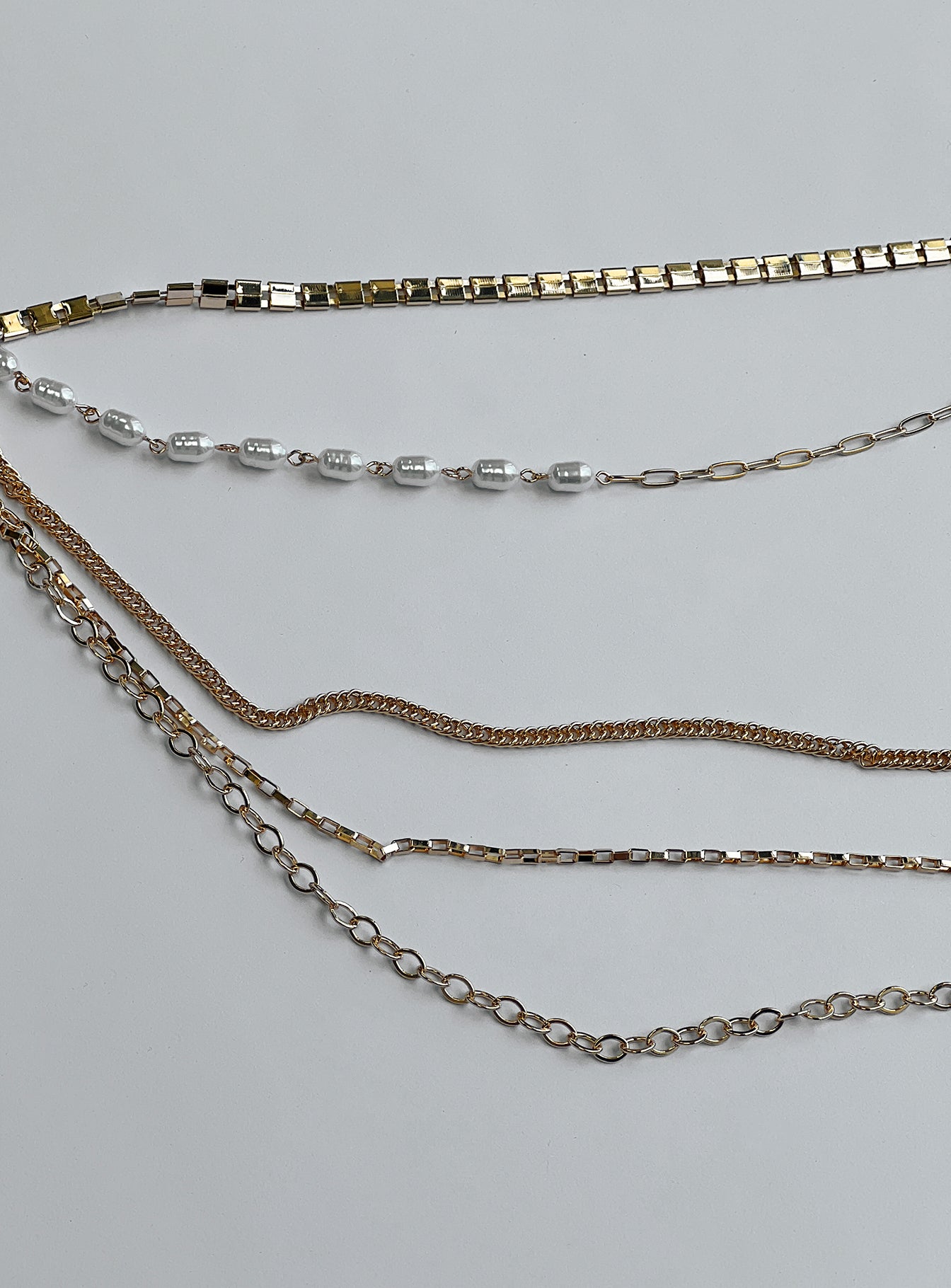 Gold toned chain belt Asymmetrical design Lobster clasp fastening Pearl detail