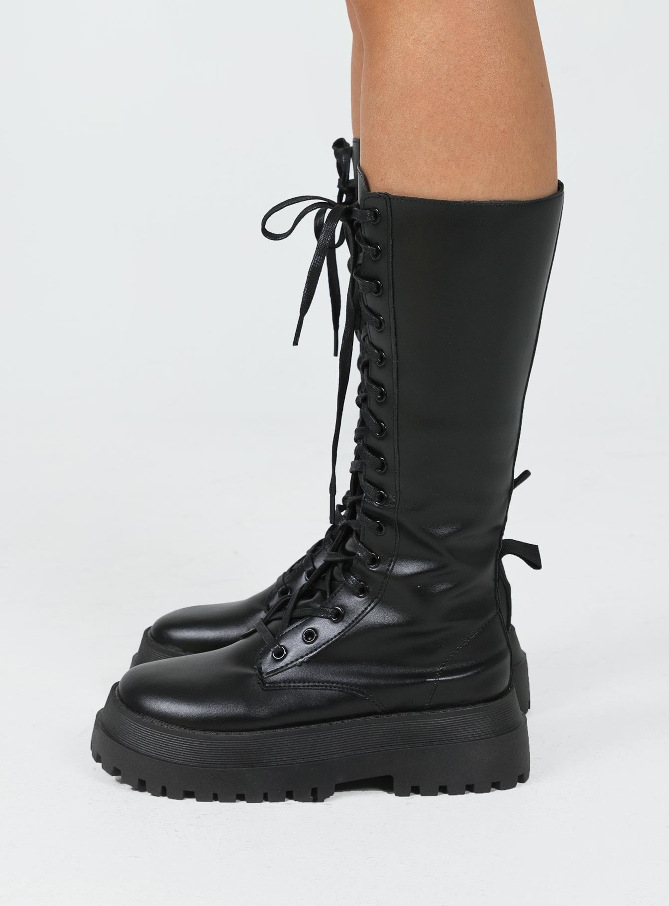 Combat boots Faux leather material  Lace up front  Zip fastening at side  Chunky base  Treaded sole  Mid-calf length 