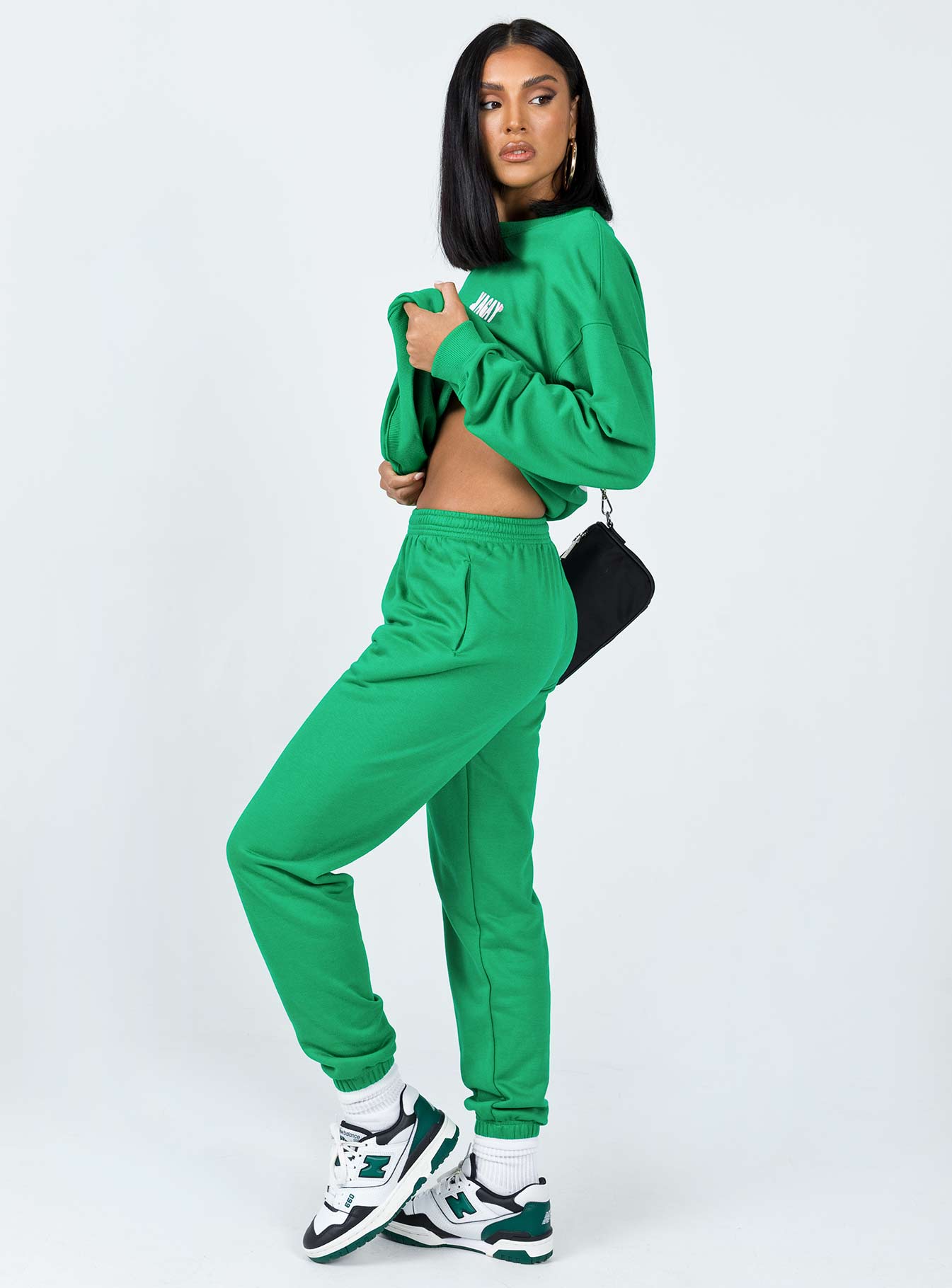 side view of model wearing Princess Polly Club Basic Trackpants Green 