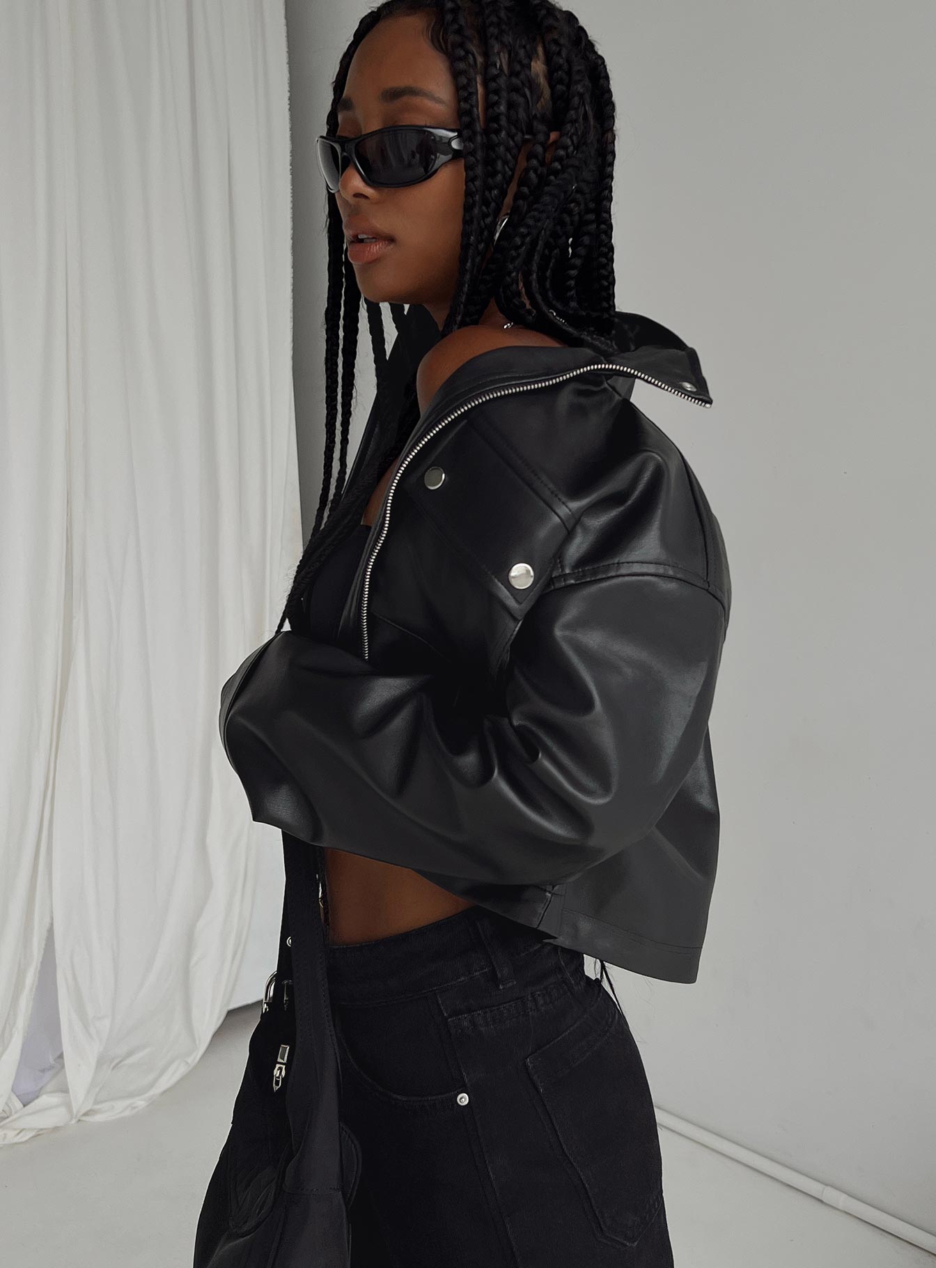 Cropped jacket Faux leather material High neck Zip & press button fastening Twin chest pockets Single button cuff