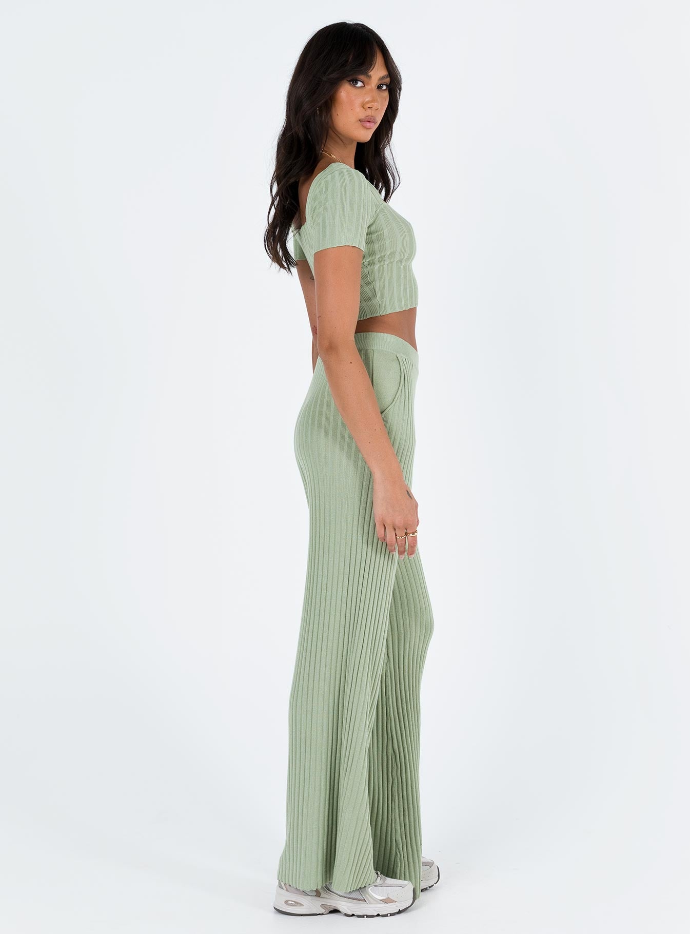 Two piece set Knit ribbed material Crop top Inner silicone strip along shoulders Wide neckline High waisted pants Thick elasticated waistband Twin hip pockets Wide flared leg