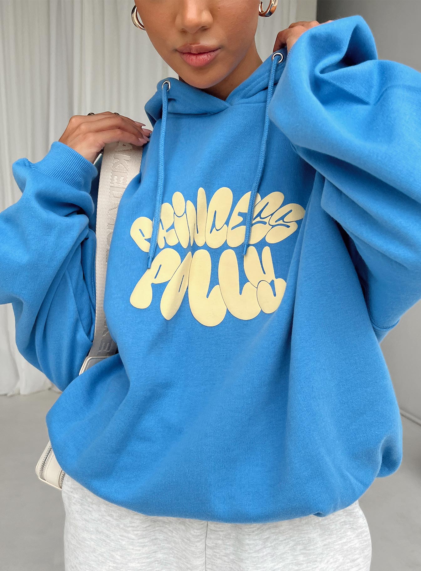 front view of model wearing Princess Polly Princess Polly Hooded Sweatshirt Bubble Text Blue / Yellow Long 
