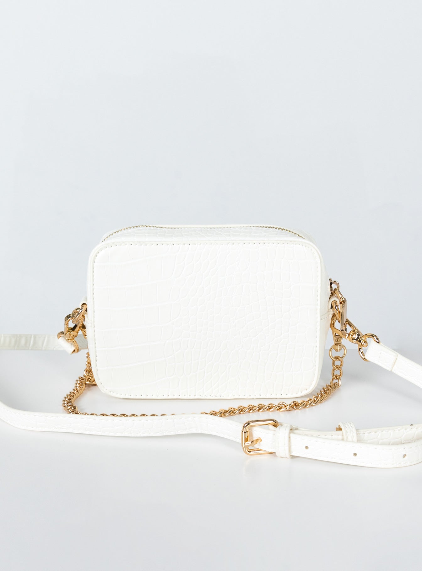 Crossbody bag 40% post-consumer recycled polyester 18% post-consumer recycled polyurethane 18% polyurethane 14% calcium carbonate 10% wood fiber Faux croc leather  Removable chain shoulder strap  Removable / adjustable crossbody strap  Zip fastening  Internal pockets  Flat base 