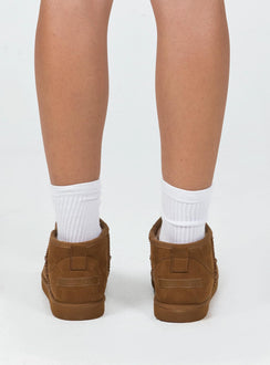 Shearling boots Princess Polly Exclusive Cropped ankle height Faux suede material Slip on style Pull tab at back Rounded toe Fluffy lining Branded patch at back