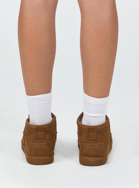 Shearling boots Princess Polly Exclusive Cropped ankle height Faux suede material Slip on style Pull tab at back Rounded toe Fluffy lining Branded patch at back