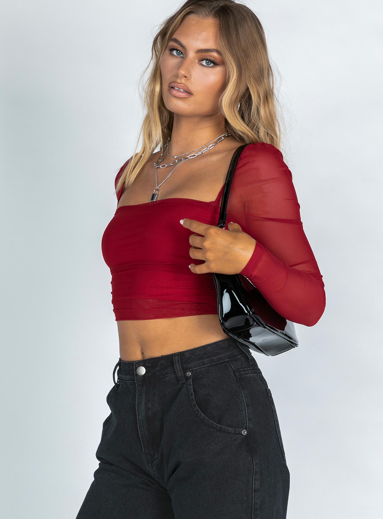 side view of model wearing Princess Polly City Lights Long Sleeve Top Red 