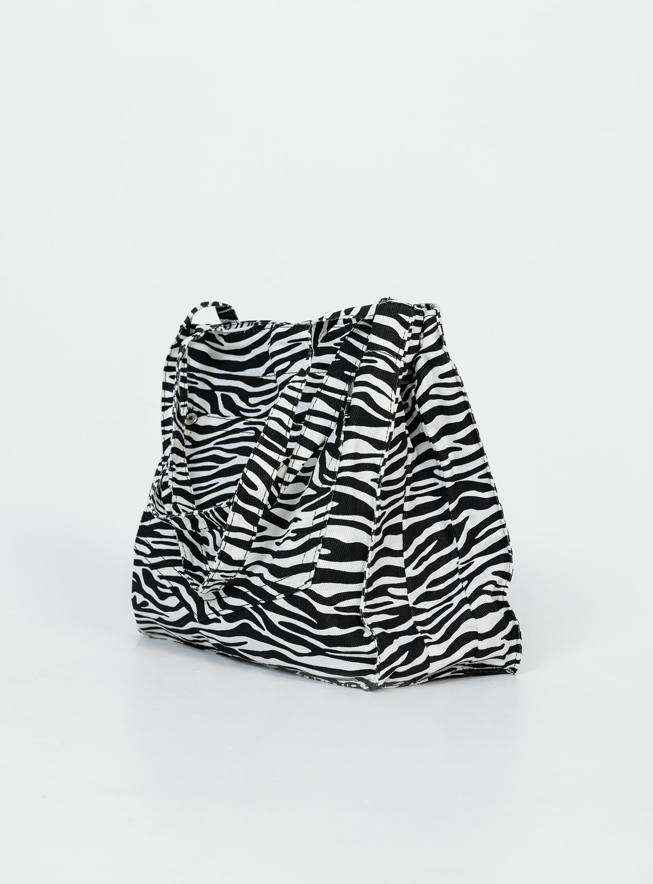 Bag  80% polyester 20% cotton Zebra print  Twin handles External & internal pockets Flat base  Magnetic button fastening 